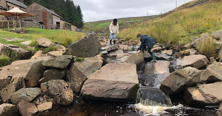 little girl and boy play in the beck at Killhope Lead Mining Museum